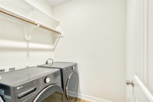 laundry room with hardwood / wood-style floors and washing machine and dryer