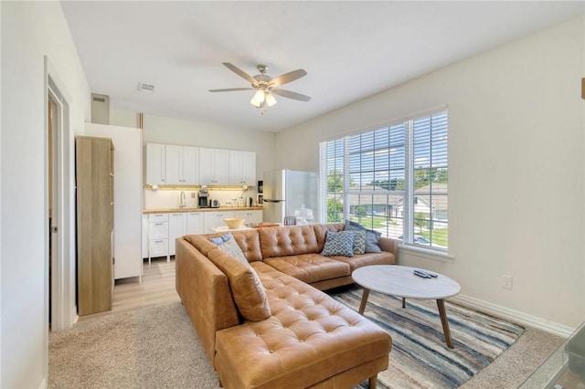 living room with ceiling fan and light hardwood / wood-style flooring