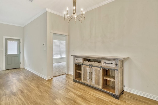 interior space with hardwood / wood-style flooring, crown molding, and a chandelier