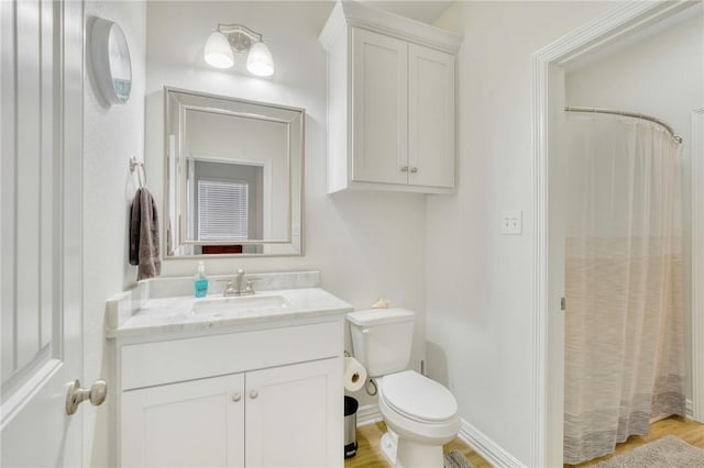 bathroom with a shower with curtain, vanity, wood-type flooring, and toilet