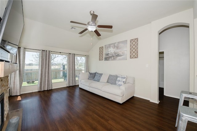 unfurnished living room with lofted ceiling, wood finished floors, visible vents, and arched walkways