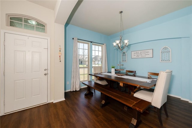 dining area featuring baseboards, arched walkways, a notable chandelier, and wood finished floors