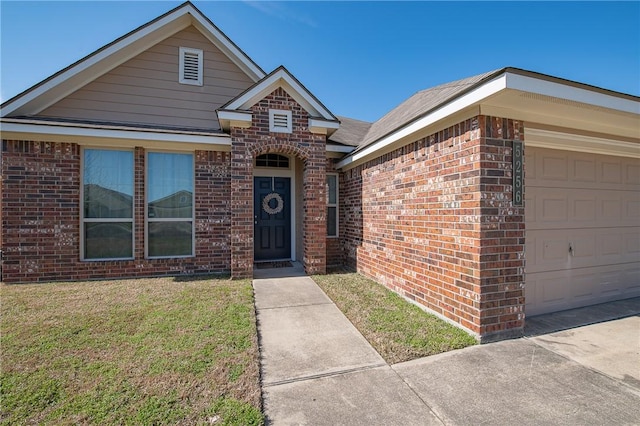 view of front of property with a front lawn, an attached garage, and brick siding