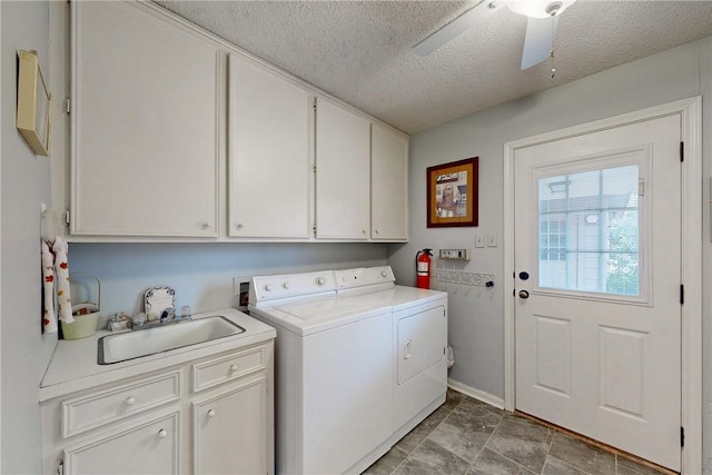 laundry area with washer and clothes dryer, cabinet space, a sink, a textured ceiling, and ceiling fan