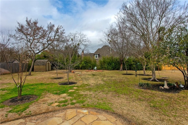 view of yard with an outbuilding, fence, and a storage shed