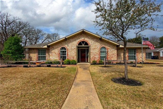 view of front of house with brick siding and a front lawn