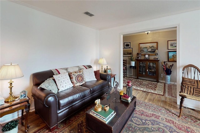 living room with baseboards, visible vents, and wood finished floors