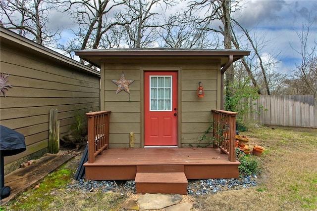 view of outdoor structure featuring fence and an outbuilding