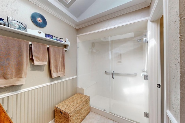 full bath with lofted ceiling, a wainscoted wall, a shower stall, and crown molding