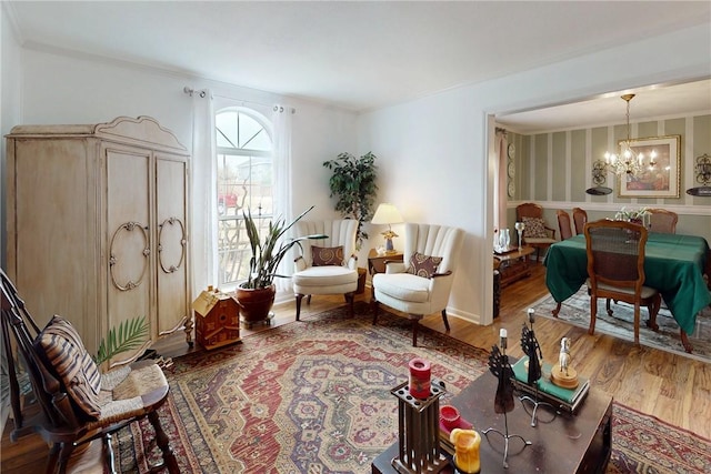 living area featuring a notable chandelier, crown molding, and wood finished floors