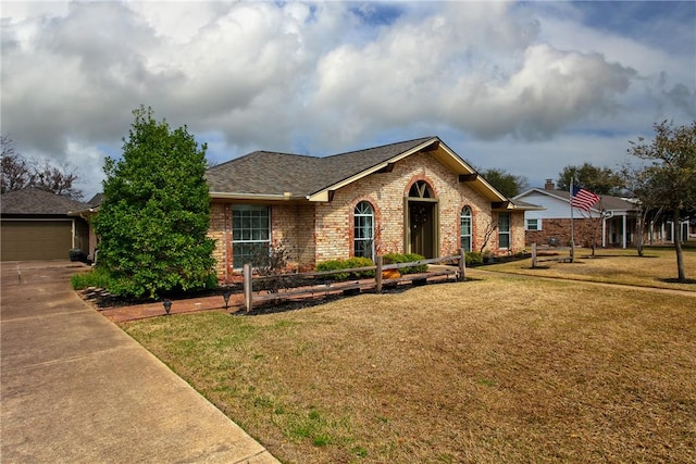 ranch-style home with brick siding, a front lawn, and a shingled roof