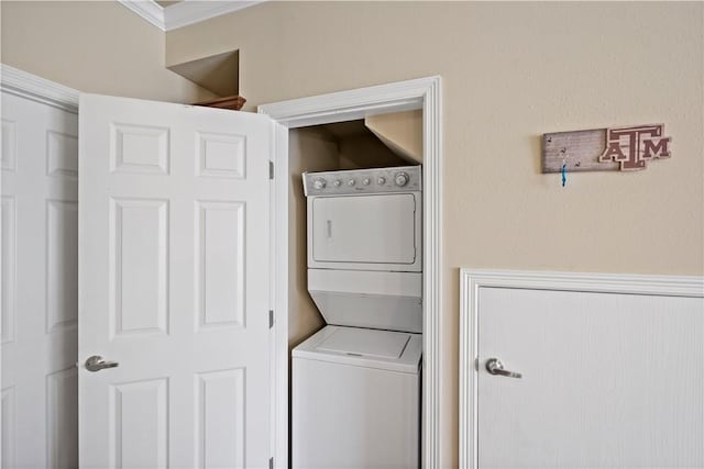 laundry room featuring ornamental molding and stacked washer and clothes dryer