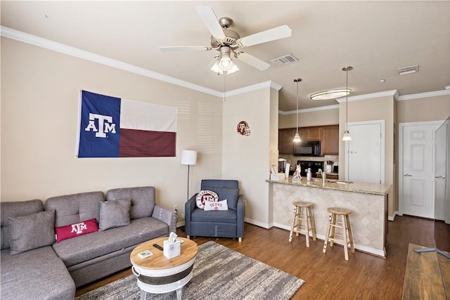 living room with ceiling fan, dark hardwood / wood-style flooring, ornamental molding, and sink