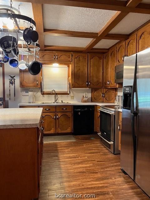 kitchen with light hardwood / wood-style flooring, beamed ceiling, coffered ceiling, and appliances with stainless steel finishes