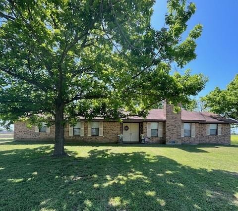 489 County Road 265, Snook, TX 77878 - ranch-style home featuring a front yard, a chimney, and brick siding