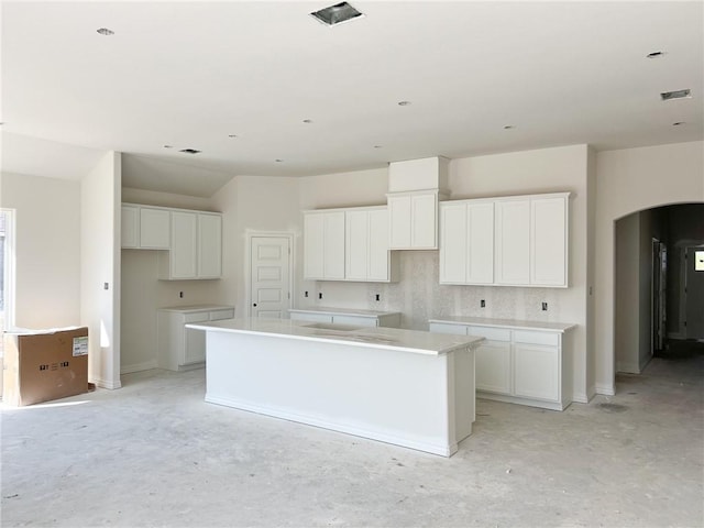 kitchen with a center island, white cabinetry, and backsplash