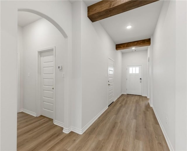 hall with beamed ceiling and light hardwood / wood-style floors