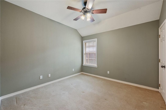 carpeted empty room featuring vaulted ceiling and ceiling fan