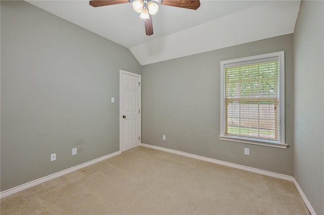 carpeted empty room with vaulted ceiling and ceiling fan