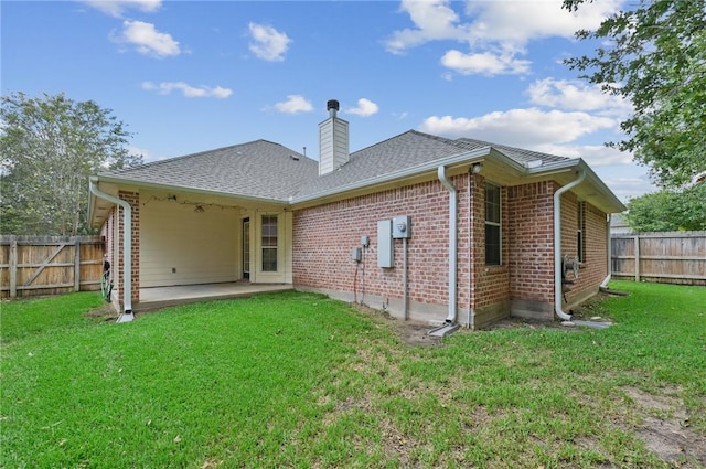 back of house featuring a lawn and a patio