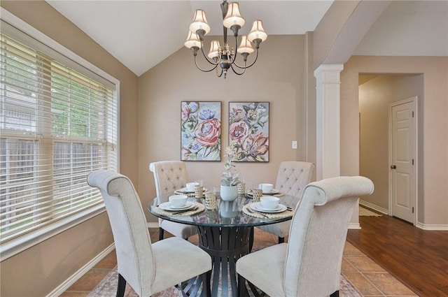 tiled dining space featuring a chandelier, vaulted ceiling, and ornate columns