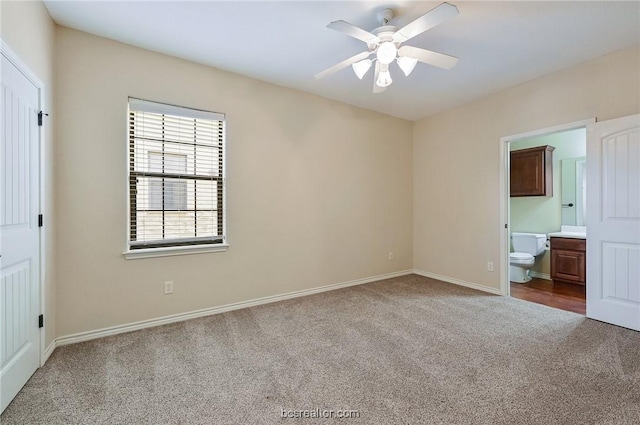 unfurnished bedroom with carpet flooring, ensuite bath, and ceiling fan