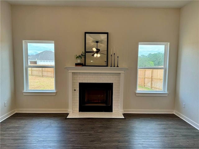 unfurnished living room featuring ceiling fan, dark hardwood / wood-style flooring, and a fireplace