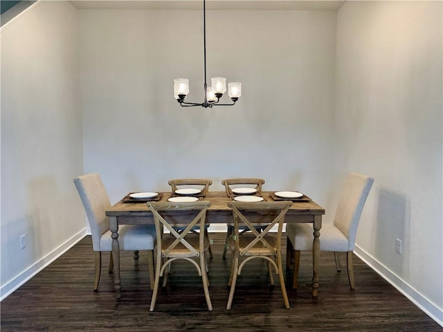 dining area featuring dark wood-type flooring and a chandelier