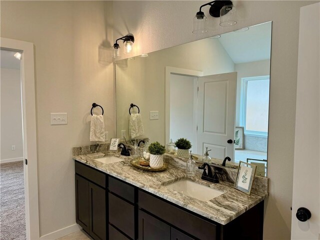 bathroom featuring vanity and lofted ceiling