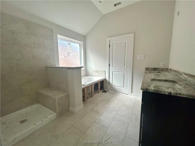 bathroom featuring tiled shower, vanity, tile patterned floors, and lofted ceiling