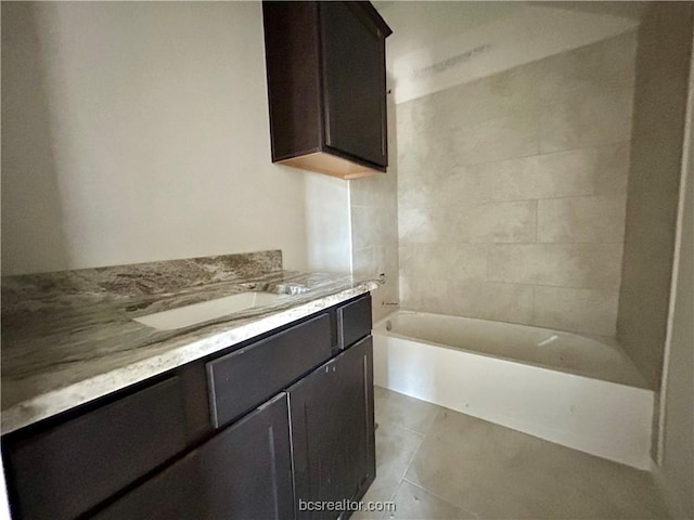 bathroom featuring tile patterned floors, a bathing tub, and vanity