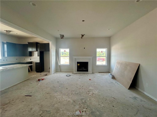 unfurnished living room with a fireplace and plenty of natural light