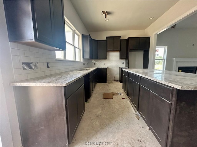 kitchen with decorative backsplash, a kitchen island, and sink