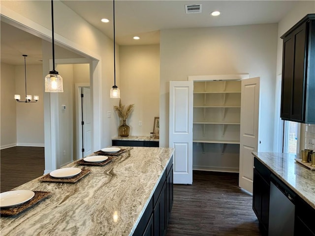 kitchen featuring decorative light fixtures, light stone countertops, and dark wood-type flooring