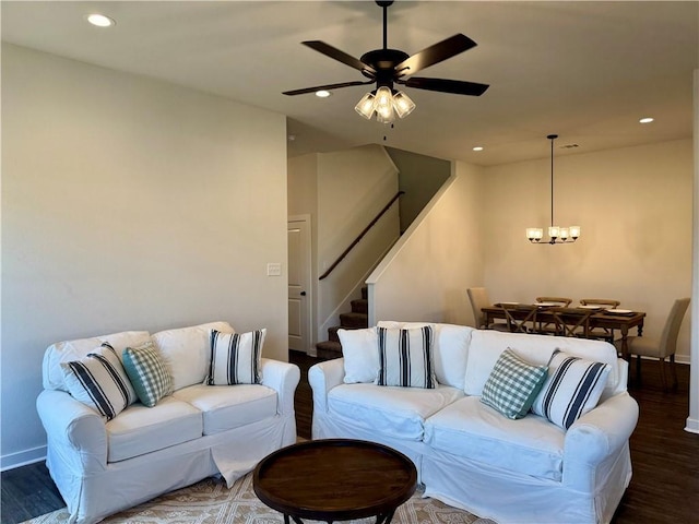 living room with dark hardwood / wood-style floors and ceiling fan with notable chandelier