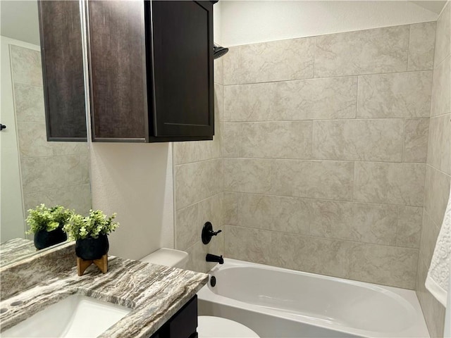 full bathroom with vanity, tiled shower / bath combo, and toilet