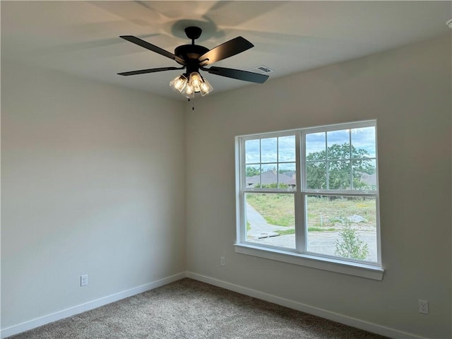 carpeted spare room featuring ceiling fan