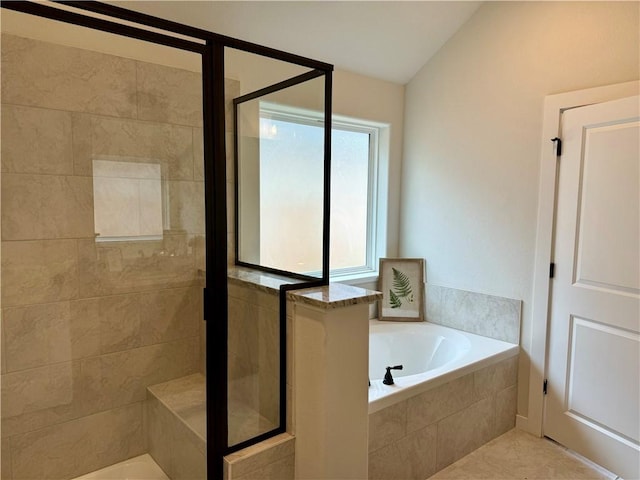 bathroom featuring shower with separate bathtub, vaulted ceiling, and tile patterned floors