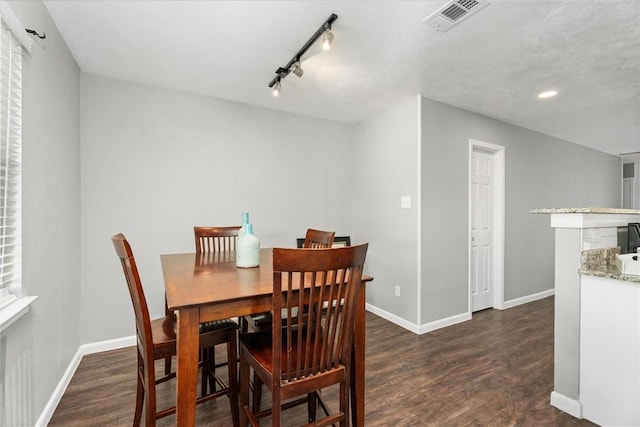 dining area featuring dark hardwood / wood-style flooring and rail lighting