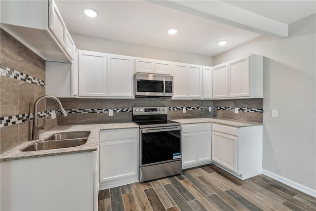 615 San Jacinto Ln, Bryan, TX 77803 - kitchen featuring stainless steel appliances, decorative backsplash, white cabinetry, light stone countertops, and dark wood-style floors