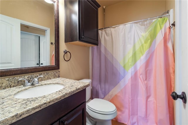 bathroom with a shower with curtain, vanity, and toilet