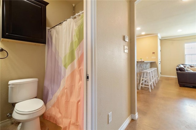 bathroom featuring crown molding and toilet