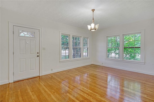 409 N Hutchins St, Bryan, TX 77803 - foyer entrance featuring a chandelier, light wood finished floors, and a textured ceiling