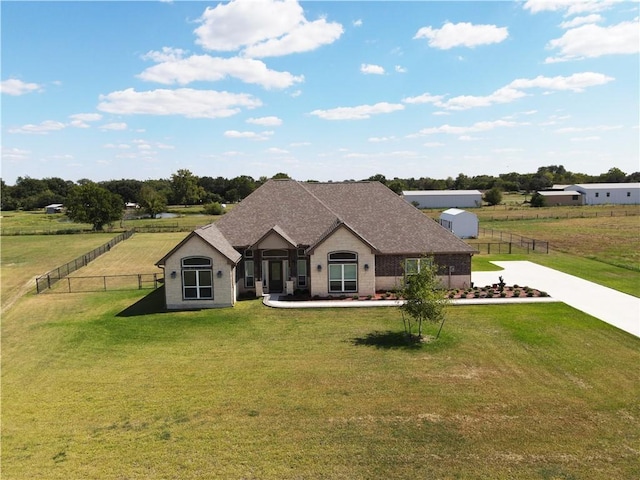 view of front facade featuring a front yard and a rural view