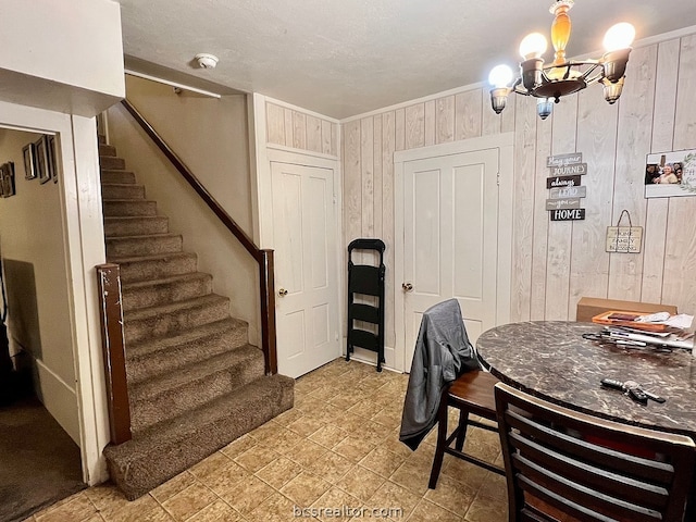 dining room with wooden walls and a chandelier