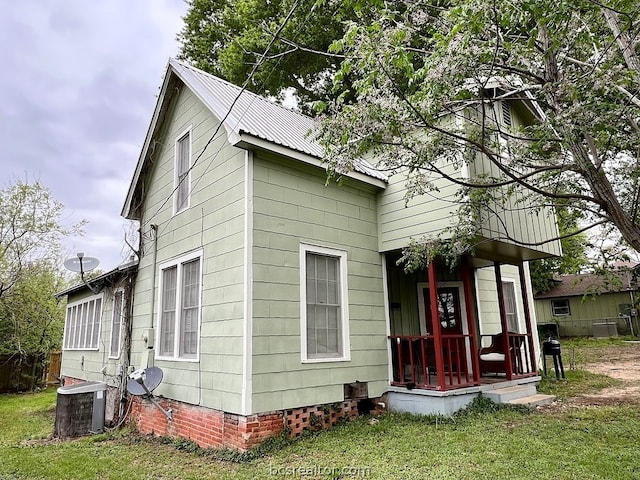 view of front of property with a porch, central air condition unit, and a front yard