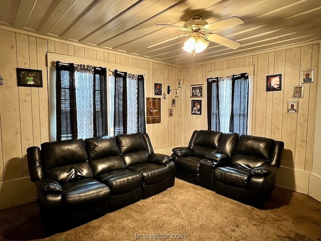 living room with wood walls, carpet floors, and ceiling fan