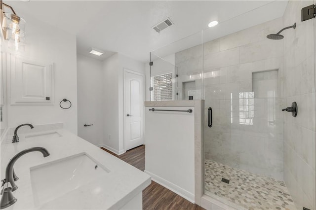 bathroom with vanity, hardwood / wood-style floors, and a shower with door