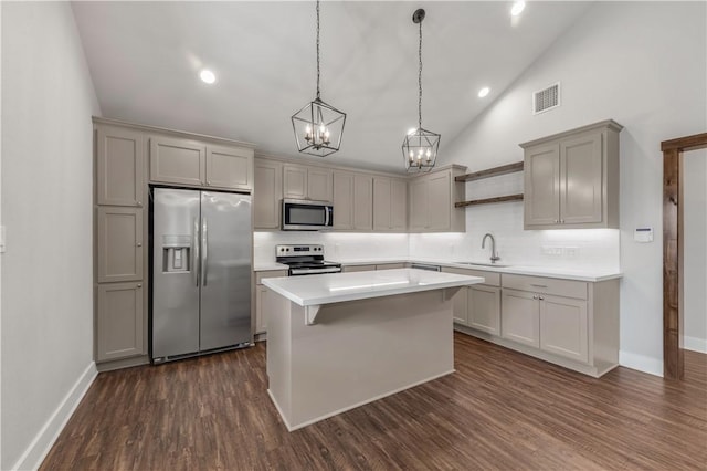 kitchen with a kitchen island, hanging light fixtures, gray cabinets, and appliances with stainless steel finishes