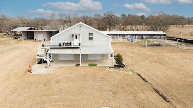 back of house with a rural view and an outdoor structure